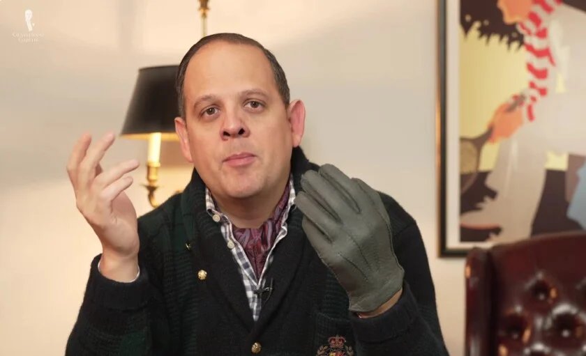 Raphael Schneider montrant une paire de gants en pécari gris.