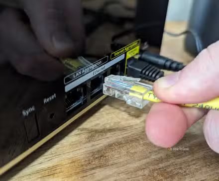 Personne connectant un câble Ethernet au routeur principal Netgear Nighthawk MK93S.