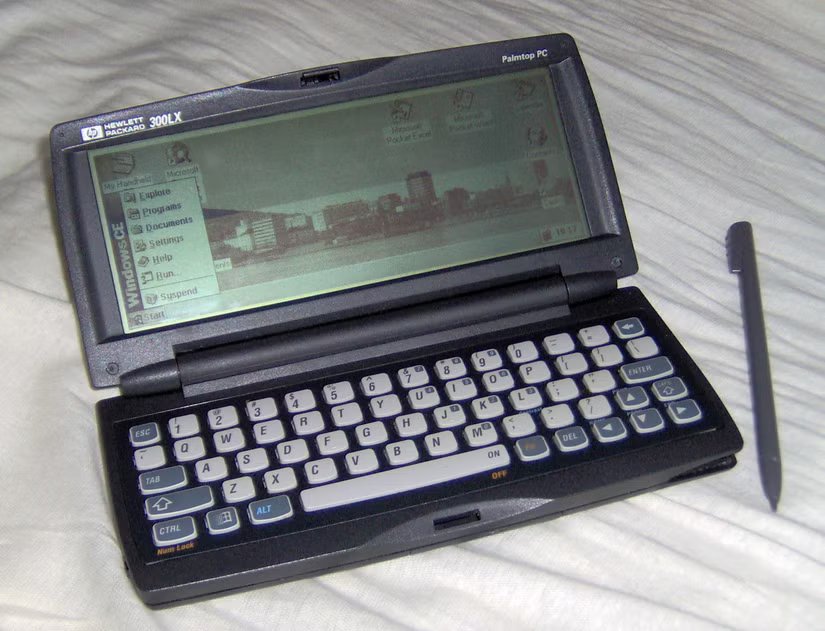 Un hpc HP 300LX avec stylet, affichant Windows CE 1.0. Le papier peint représente l'horizon de la ville norvégienne de Bergen.