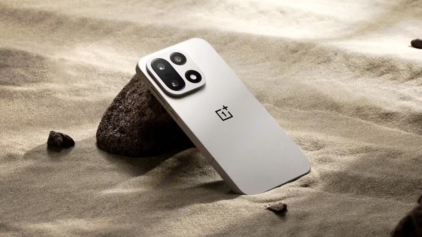 OnePlus 15 assis dans du sable. 