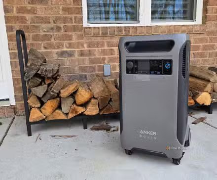 Générateur solaire portable Anker F3800 devant un support à bois de chauffage