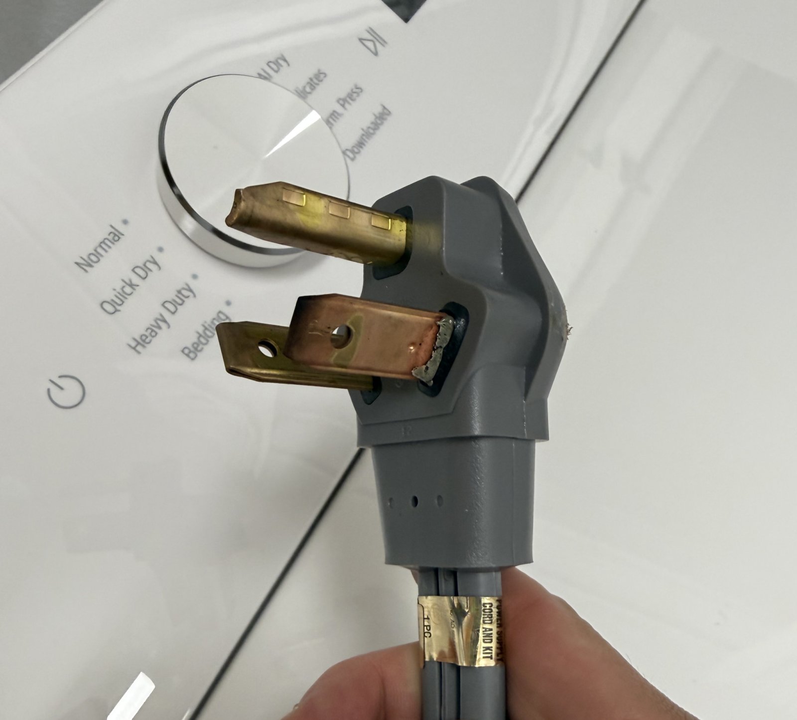 Broche brûlée d'un cordon de sécheuse à trois broches après la deuxième utilisation de la sécheuse