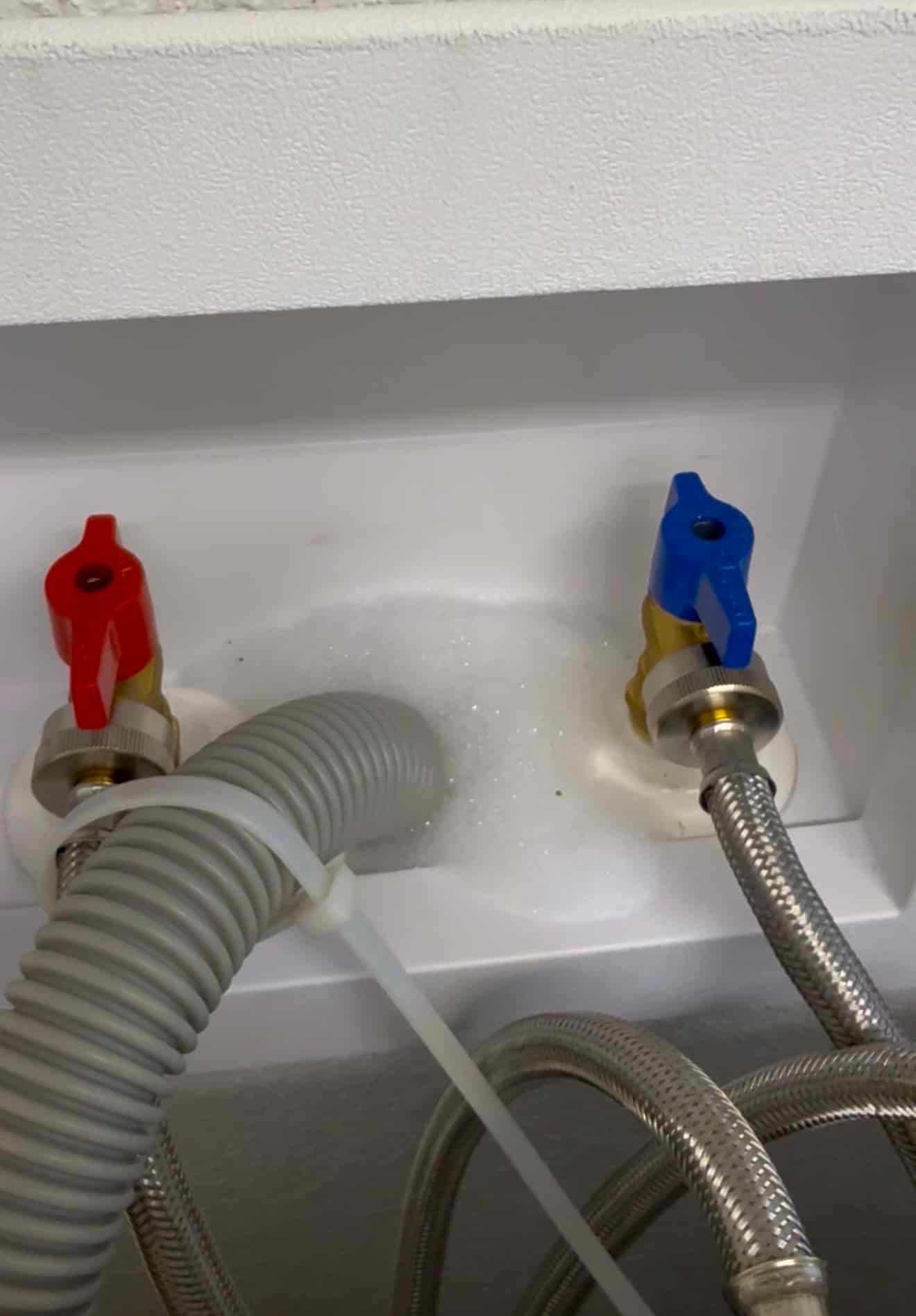 Du détergent pétillant s'élève jusqu'à l'évacuation du linge avant