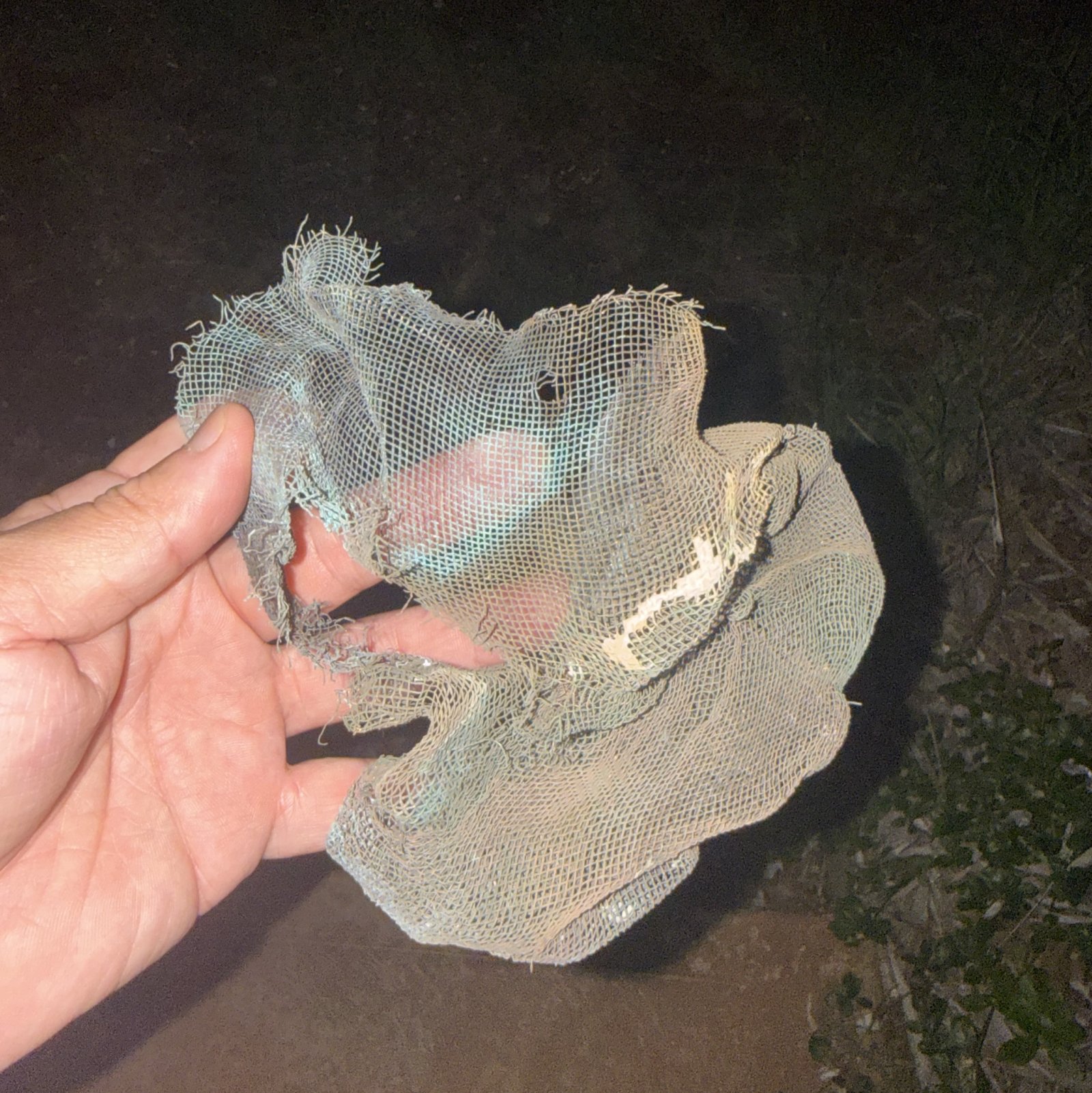 Une boule de treillis métallique avec de la peinture brûlée sur le sol juste à l'extérieur de l'évent