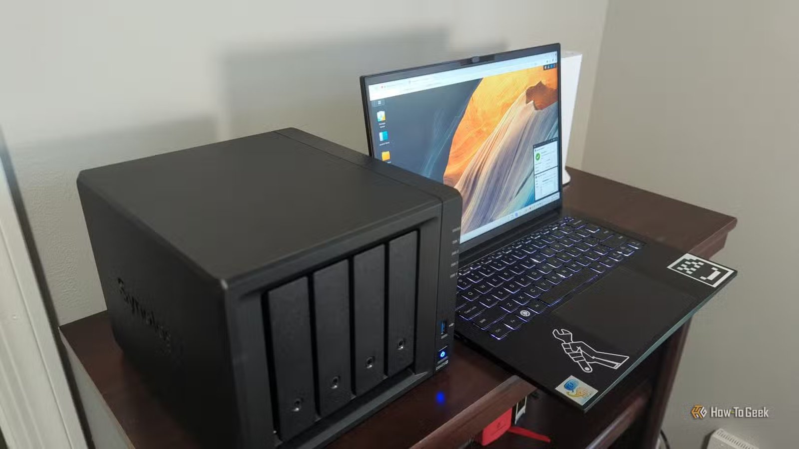 Le NAS Synology DS425+ à côté d'un ordinateur portable affichant le système d'exploitation DSM.-2
