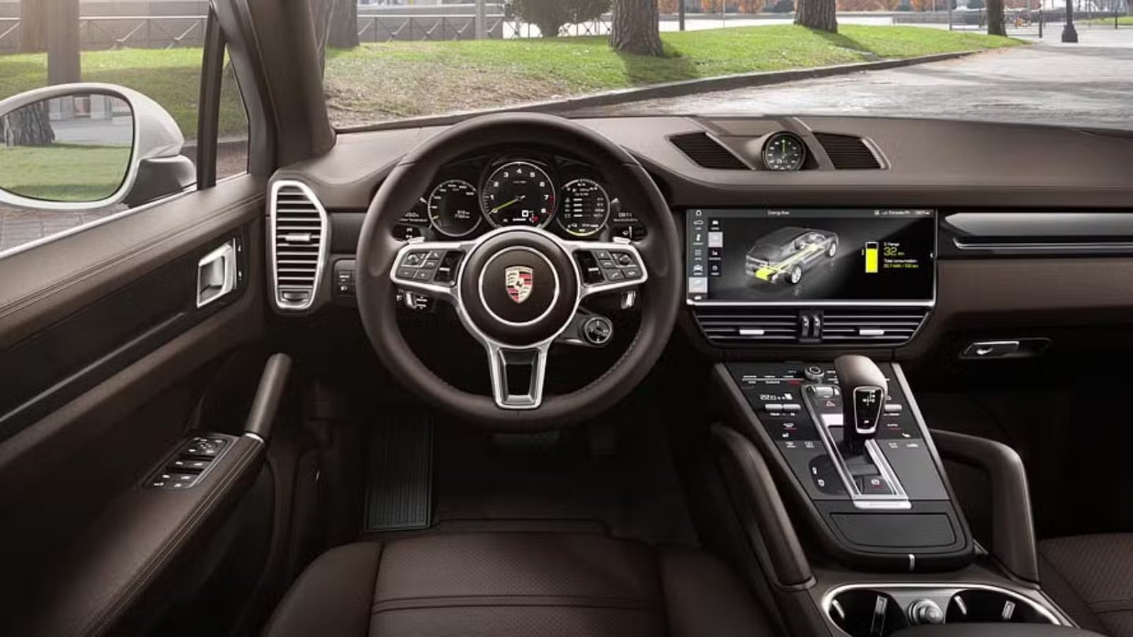 Prise de vue à l'intérieur de l'habitacle d'une Porsche Cayenne E-Hybrid 2018 montrant le volant et le tableau de bord.