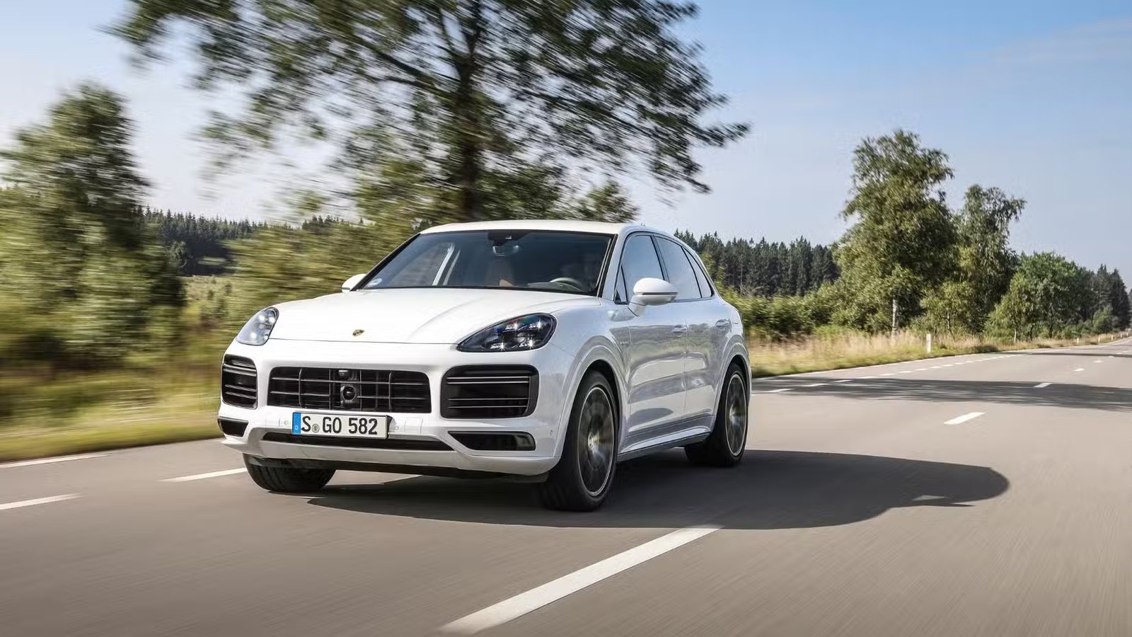 Plan dynamique 3/4 avant d'une Porsche Cayenne Turbo S E-Hybrid 2020 blanche.