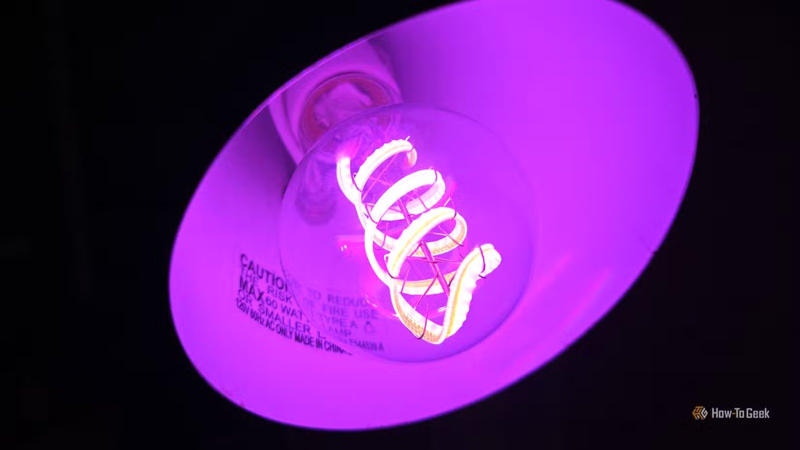 Ampoule intelligente Cync Clear Full Color Direct Connect dans une lampe, violet brillant.