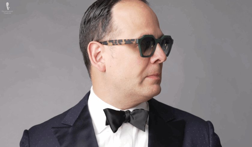 Étui à lunettes de soleil prototype Fort Belvedere Raphael Schneider porte des lunettes de soleil vertes avec des branches en écaille de tortue et un smoking.