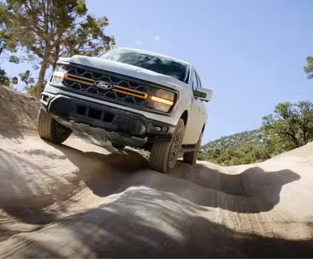 Prise de vue dynamique de l'avant d'un Ford F-150 Tremor 2024 tout-terrain.