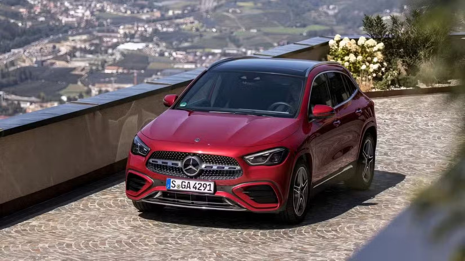 Prise de vue avant en grand angle d'une Mercedes-Benz Classe GLA 2026 en rouge en train de rouler