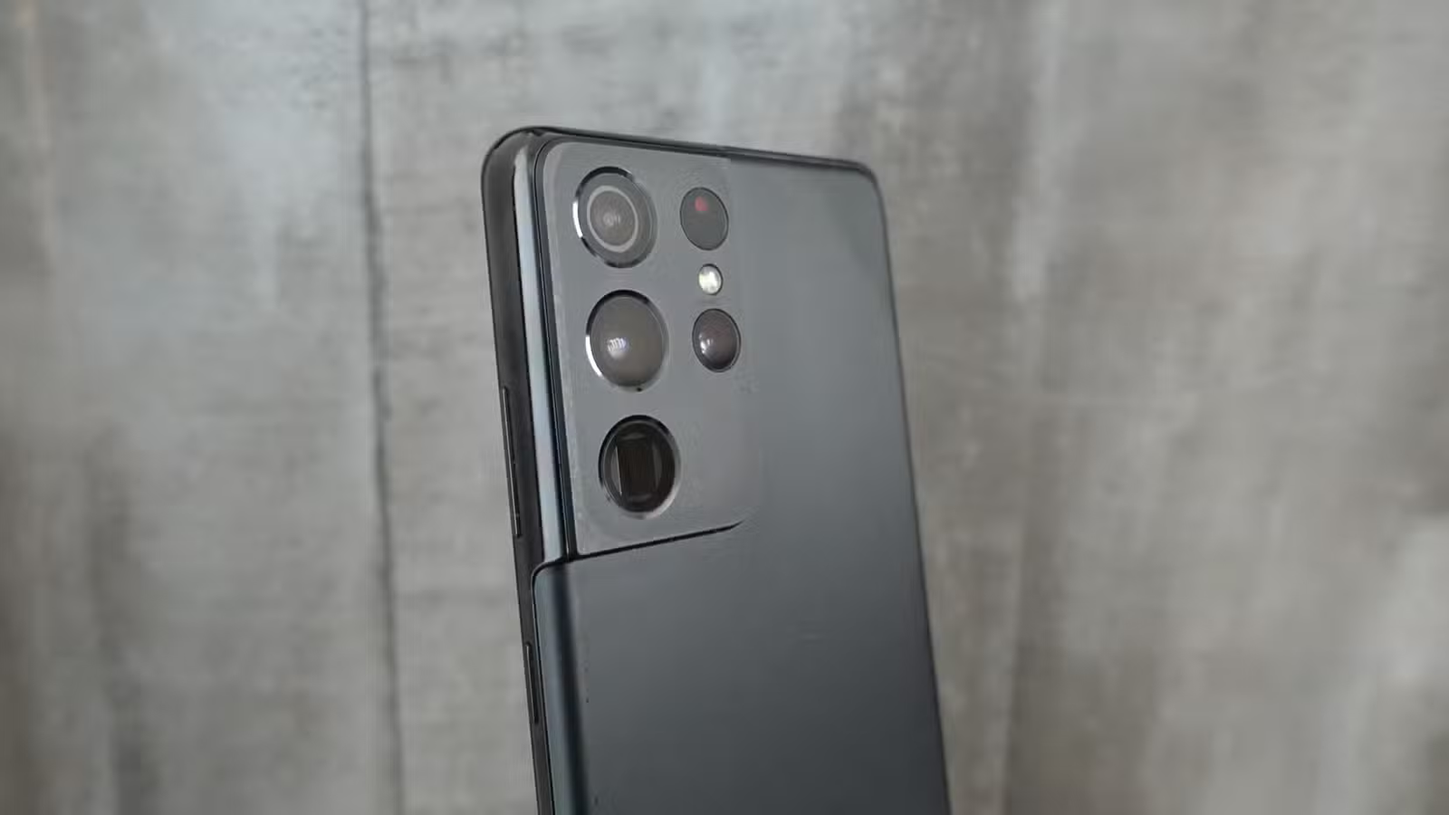 Le Samsung Galaxy S21 Ultra devant un mur de briques. 