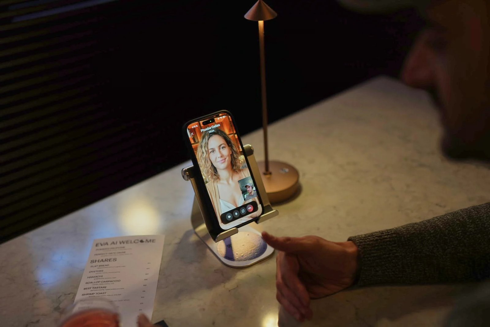 Un homme parlant à un écran de téléphone montrant une femme générée par l'IA