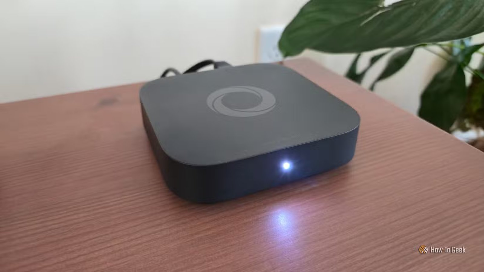 Un hub pour maison intelligente Homey Pro Mini sur un meuble TV.