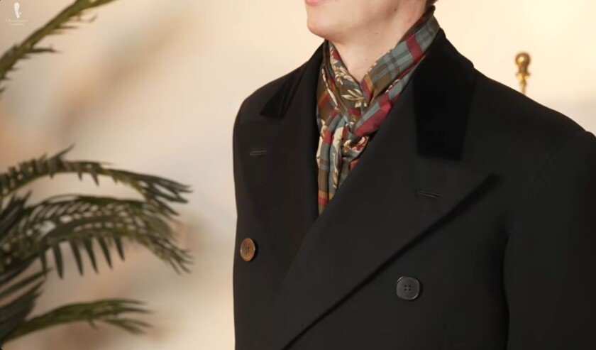 Écharpe en soie avec pardessus Gros plan d'un homme portant un foulard en soie à motifs avec un pardessus sombre à double boutonnage
