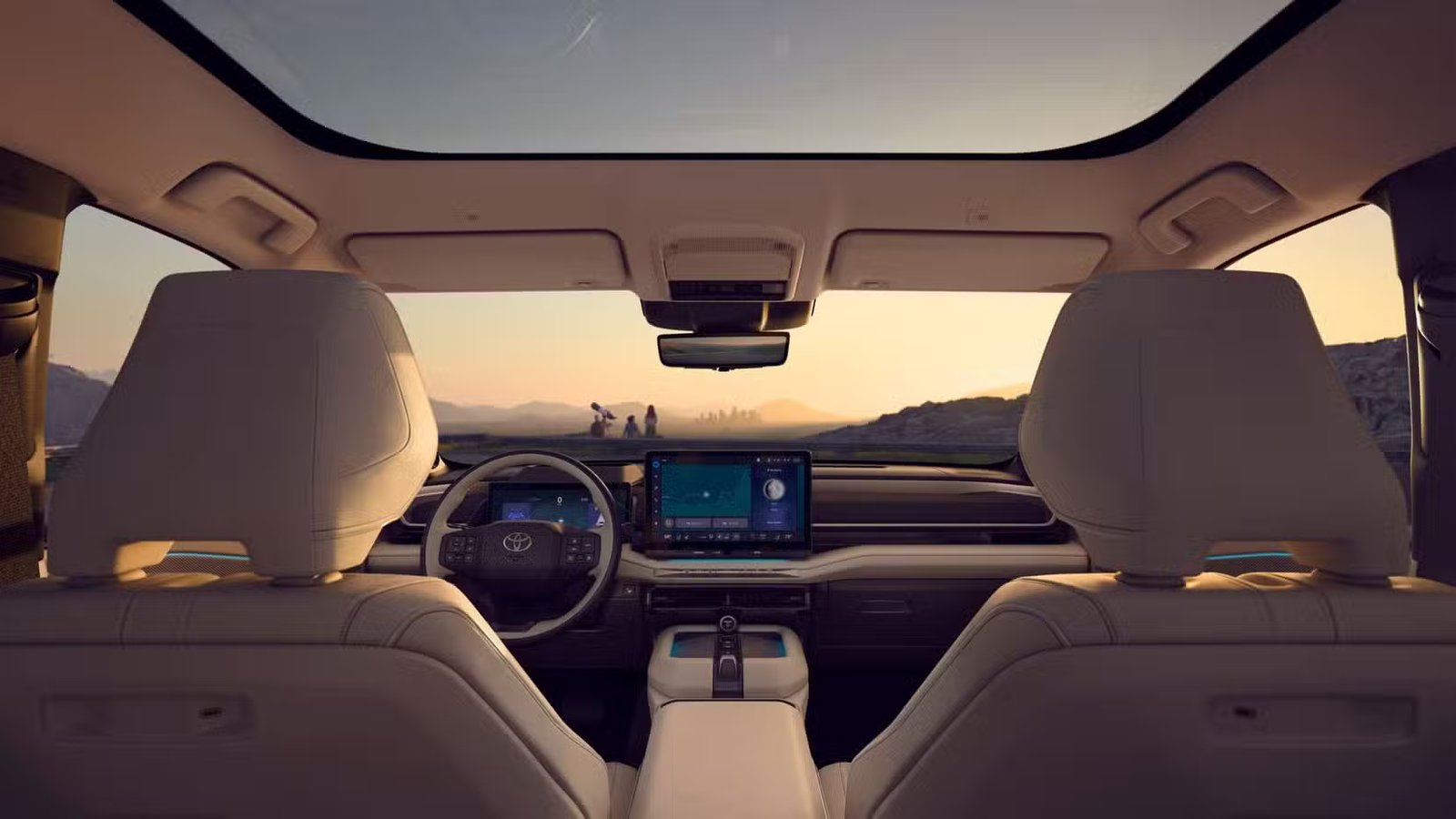 Prise de vue à l'intérieur de l'habitacle d'un Toyota Highlander Limited 2027, montrant le toit panoramique, les sièges avant et le tableau de bord.
