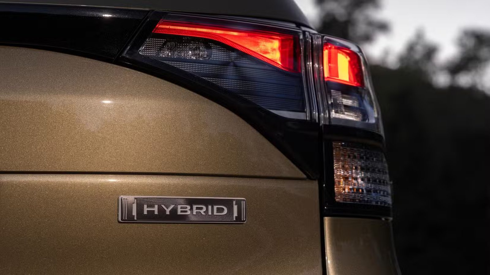 Gros plan de l'inscription « Hybride » sur le hayon d'une Subaru Forester hybride 2025 verte.