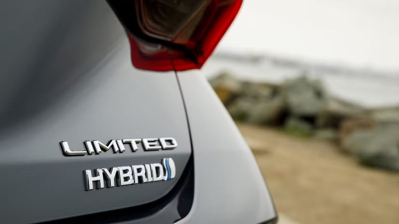 Gros plan de l'emblème sur le hayon d'une Toyota Avalon Hybrid Limited 2022 grise.