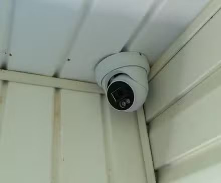 Une caméra de sécurité PoE installée dans le coin d'un porche.