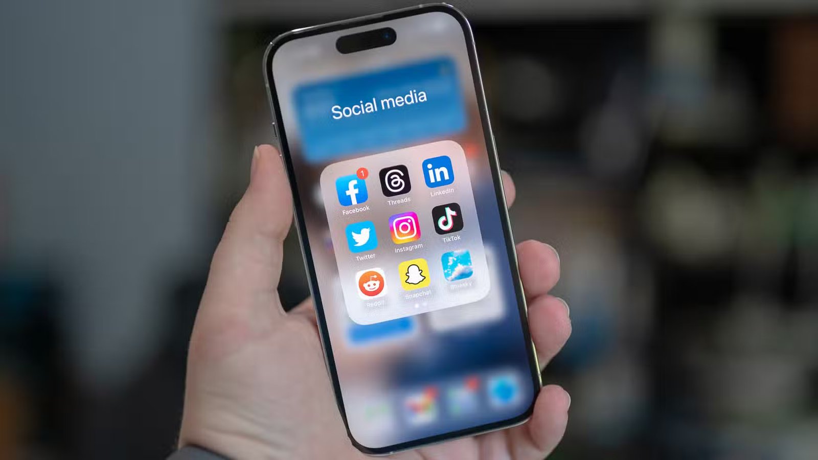 Dossier de réseaux sociaux sur un Apple iPhone 14 Pro avec les applications Facebook, Threads, LinkedIn, Twitter, Instagram, TikTok, Reddit, Snapchat et Bluesky.