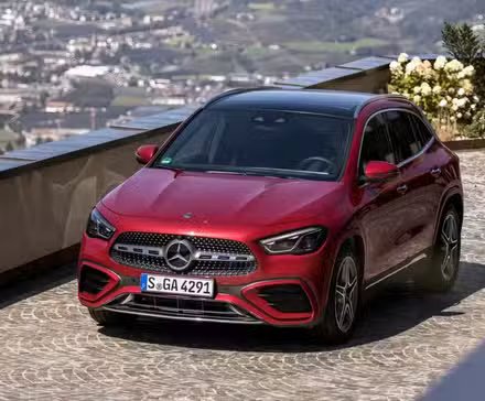 Prise de vue avant en grand angle d'une Mercedes-Benz Classe GLA 2026 en rouge en train de rouler