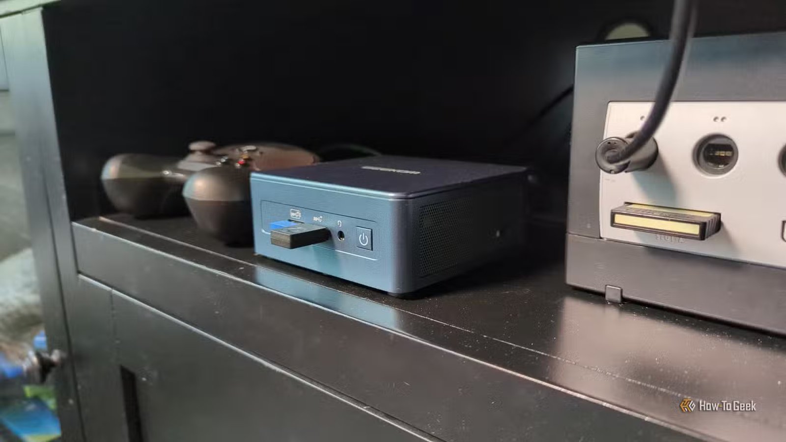 Un mini PC avec un Steam Controller et un Gamecube dans un centre de divertissement.