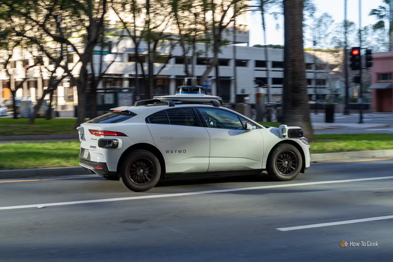 Un SUV Jaguar I-PACE autonome Waymo roulant dans une rue de la ville.