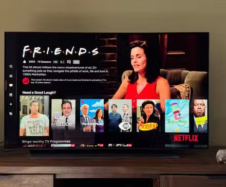 Télévision 4K dans un salon vert diffusant Friends et d'autres émissions réconfortantes sur Netflix.