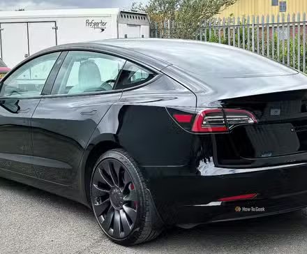 Plan 3/4 arrière statique d'une Tesla Model 3 Performance 2021 noire.