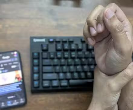 Se tenir la main à cause de la douleur des brefs sur un clavier.