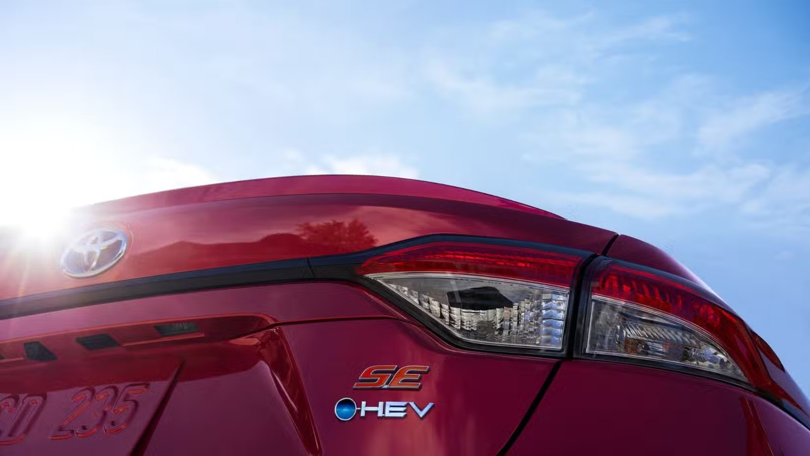 Gros plan des insignes à l’arrière d’une Toyota Corolla hybride 2025 rouge.