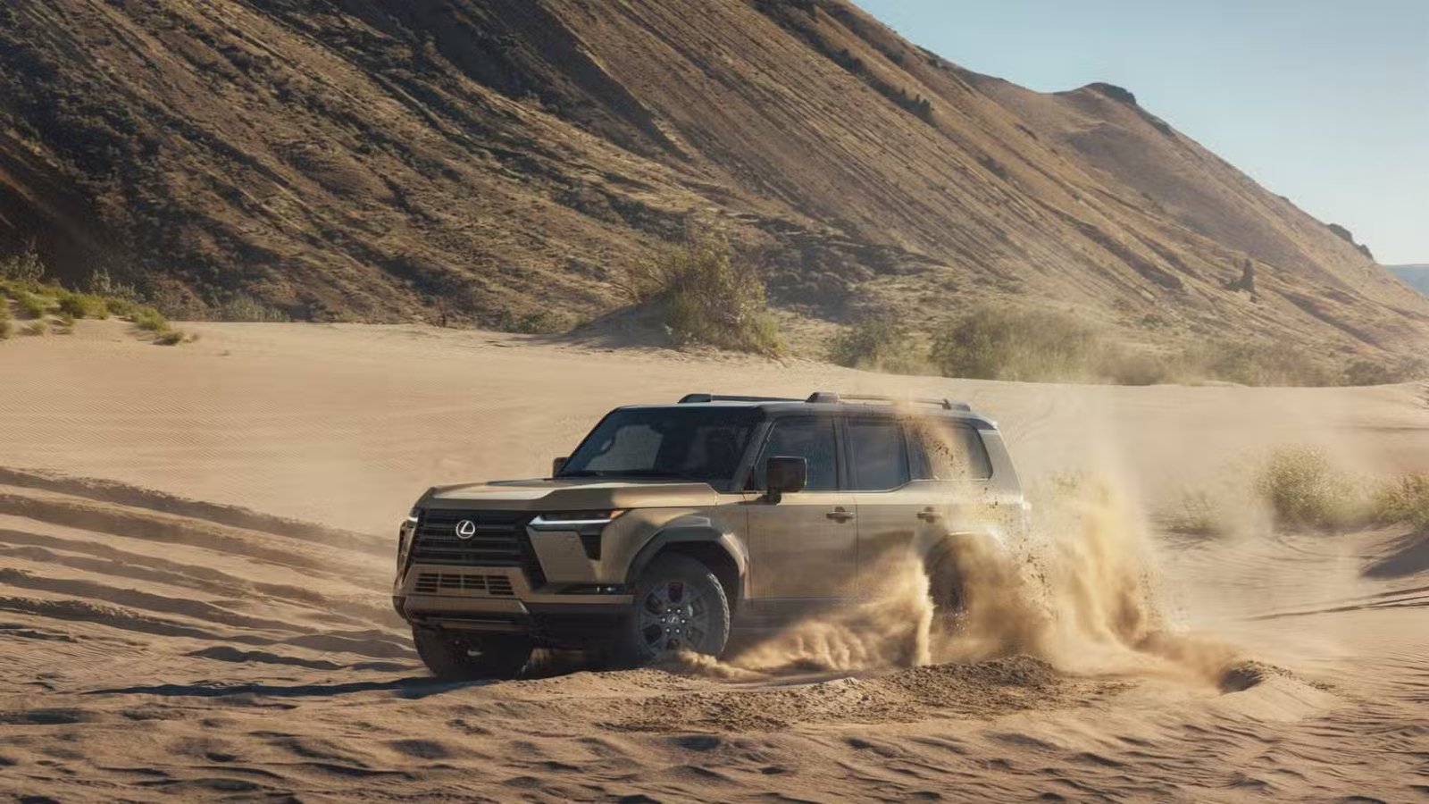 Vue 3/4 avant d'un tout-terrain Lexus GX 2025 doré dans le sable.