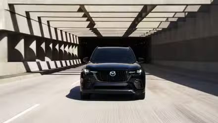 Prise de vue dynamique de l'avant d'un Mazda CX-70 2026 noir.