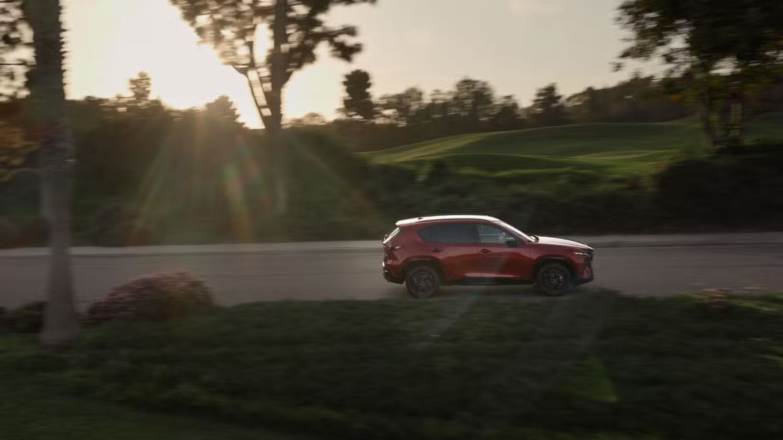 Photo de profil latérale dynamique d'une Mazda CX-5 2026 rouge.
