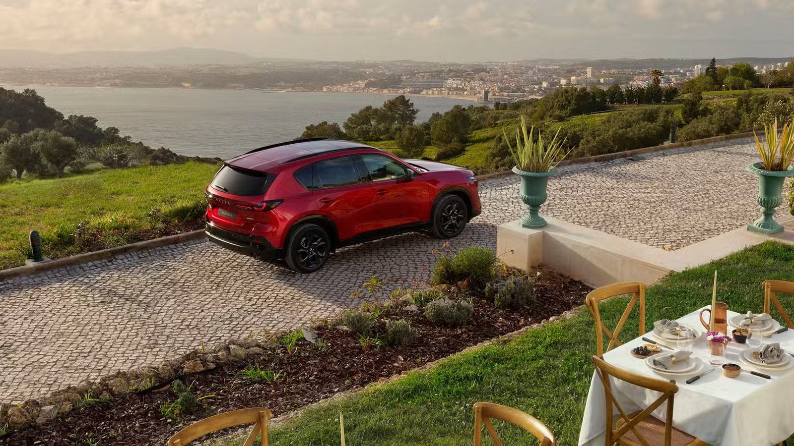 Plan 3/4 arrière statique au-dessus d'une Mazda CX-5 2026 rouge.