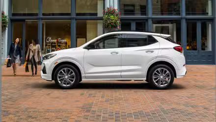 Plan latéral statique d'une Buick Encore GX 2021 blanche garée dans une ville.