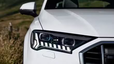 Gros plan du phare d’une Audi Q7 2020 blanche.