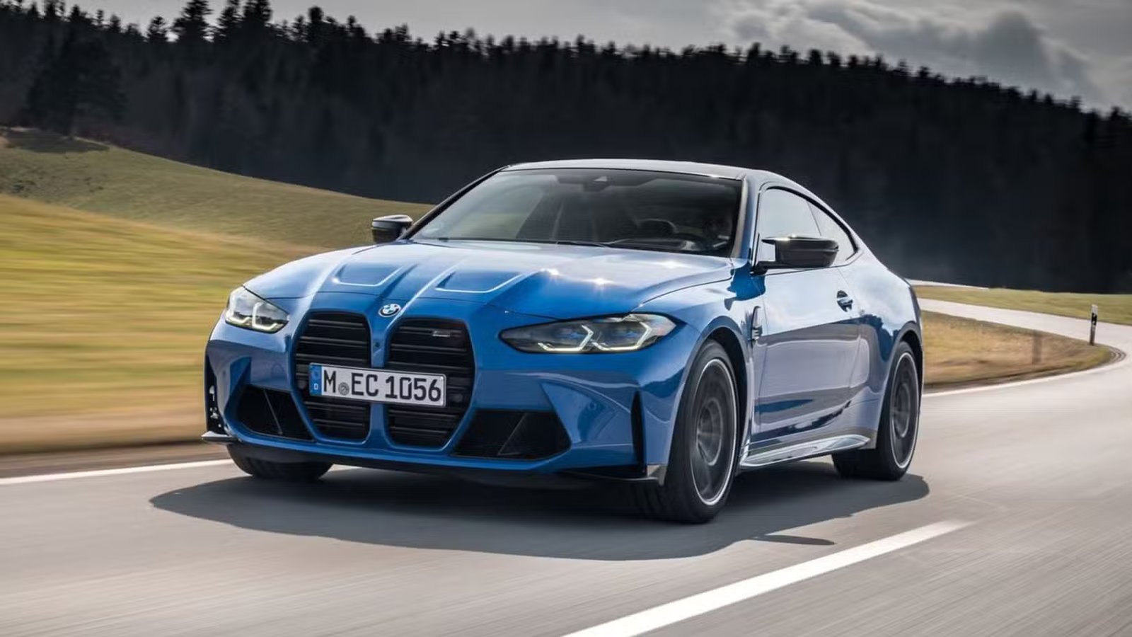 Plan dynamique 3/4 avant d'une BMW M4 Competition Coupé xDrive 2022 bleue.