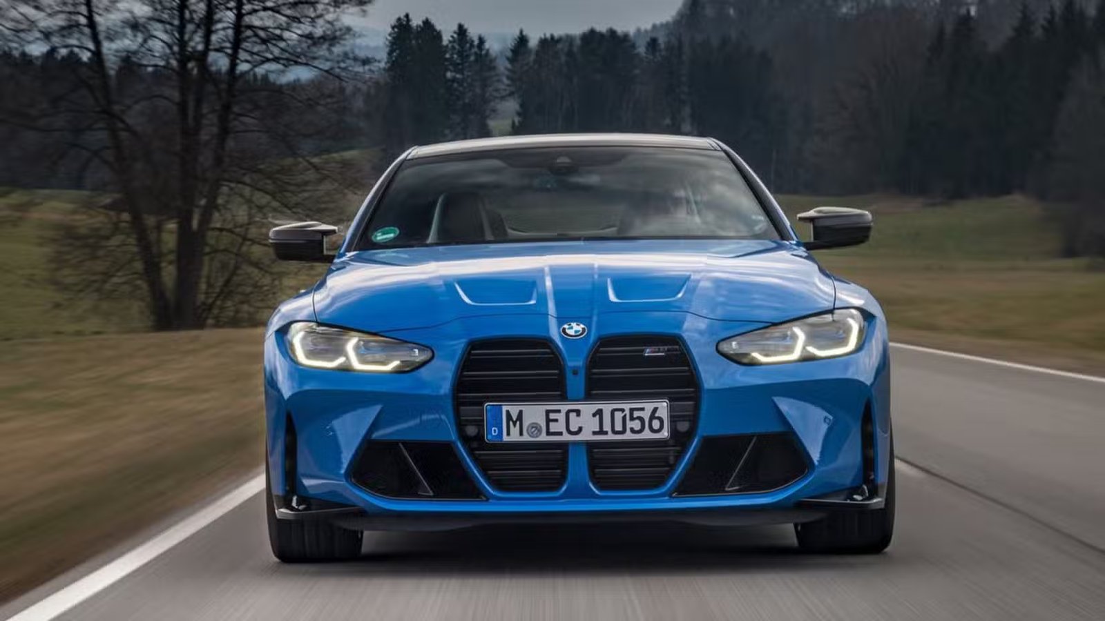 Photo avant dynamique d'une BMW M4 Competition Coupé xDrive 2022 bleue.