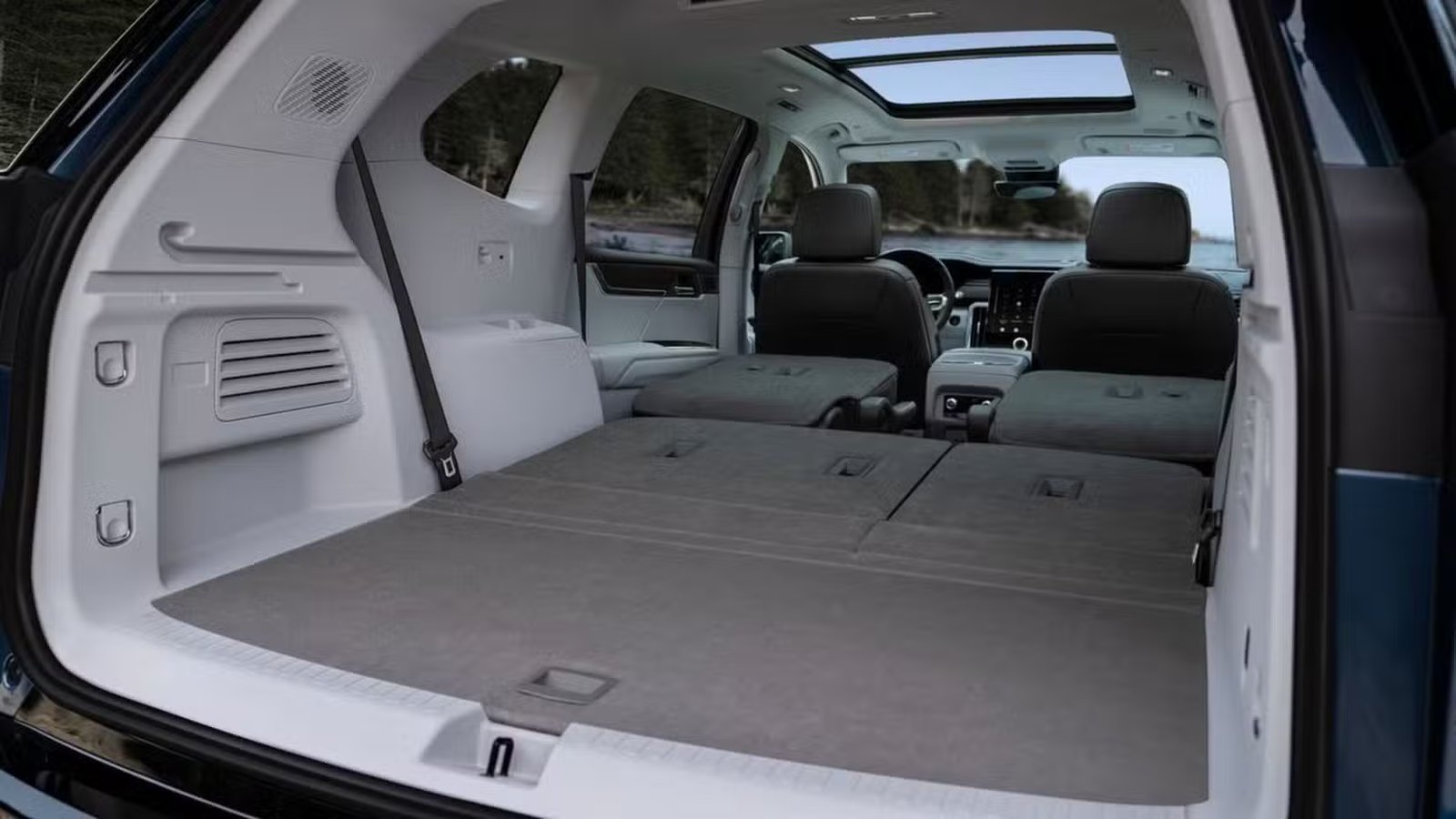 Prise de vue à l'intérieur du coffre d'un GMC Acadia 2024 avec les sièges des deuxième et troisième rangées rabattus.