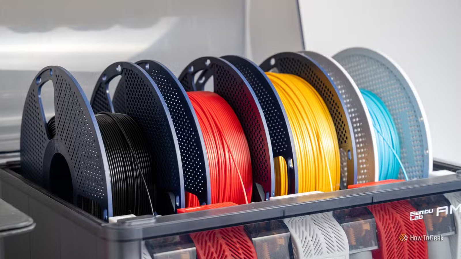 Plusieurs bobines colorées de filament d'imprimante 3D chargées dans une unité Bambu Lab AMS.