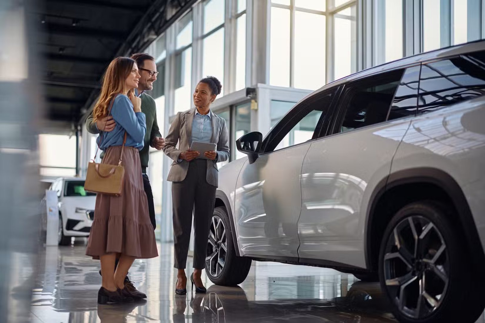 Couple achetant une nouvelle voiture dans une salle d'exposition d'un concessionnaire