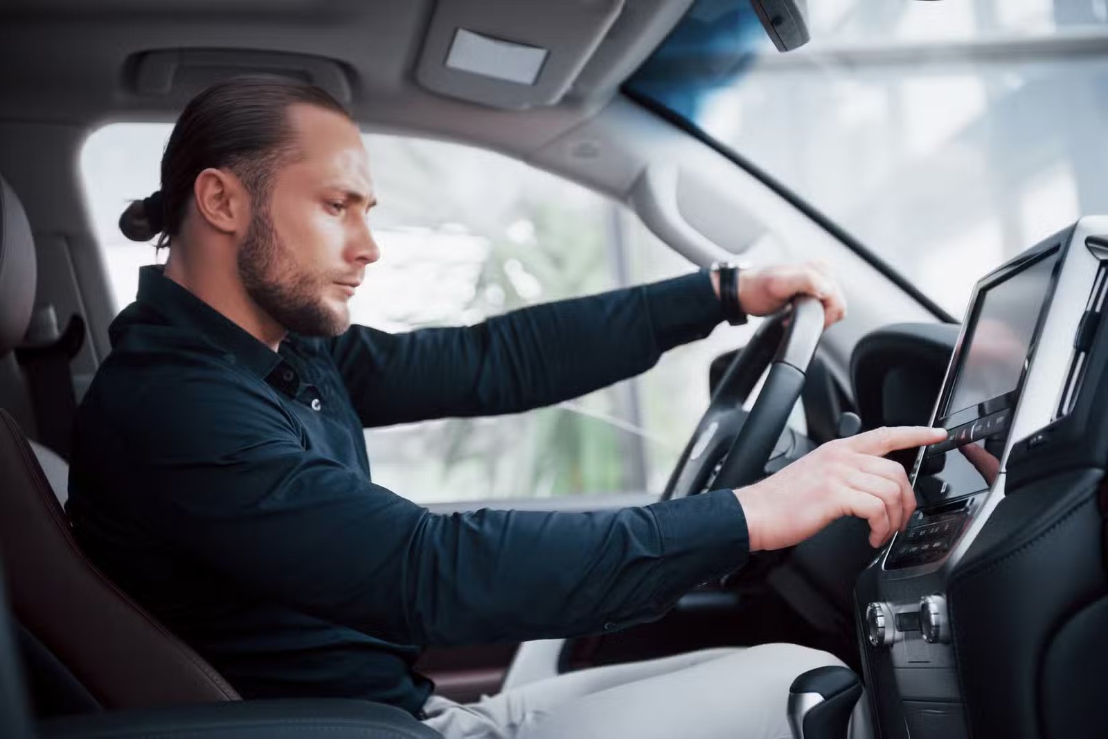 Homme réglant les paramètres de l’écran tactile dans une voiture