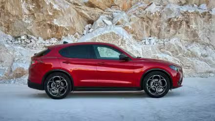 Photo de profil latérale statique d'une Alfa Romeo Stelvio 2023 rouge.