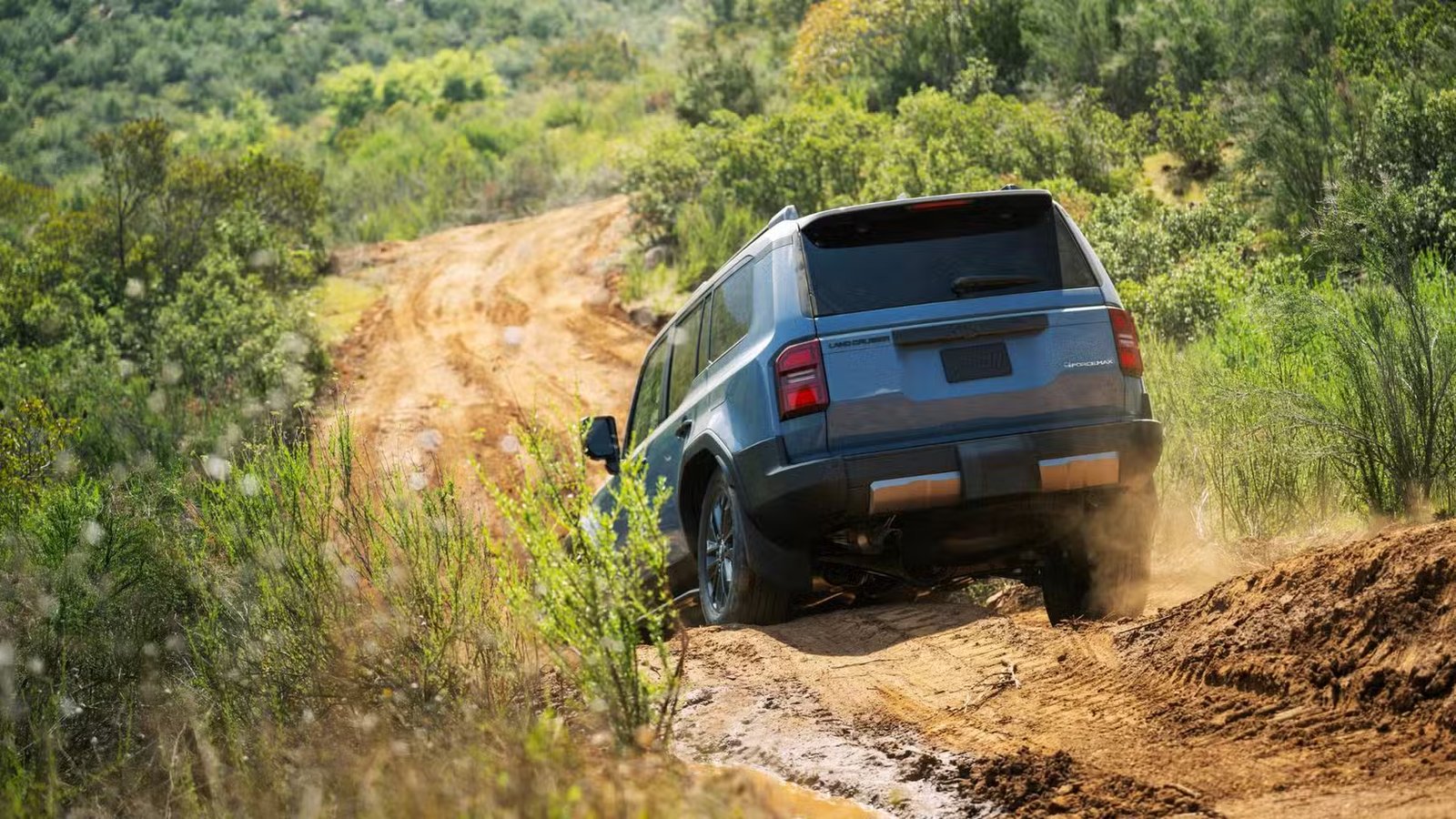 Prise de vue dynamique de l'arrière d'un Land Cruiser 2026 bleu.