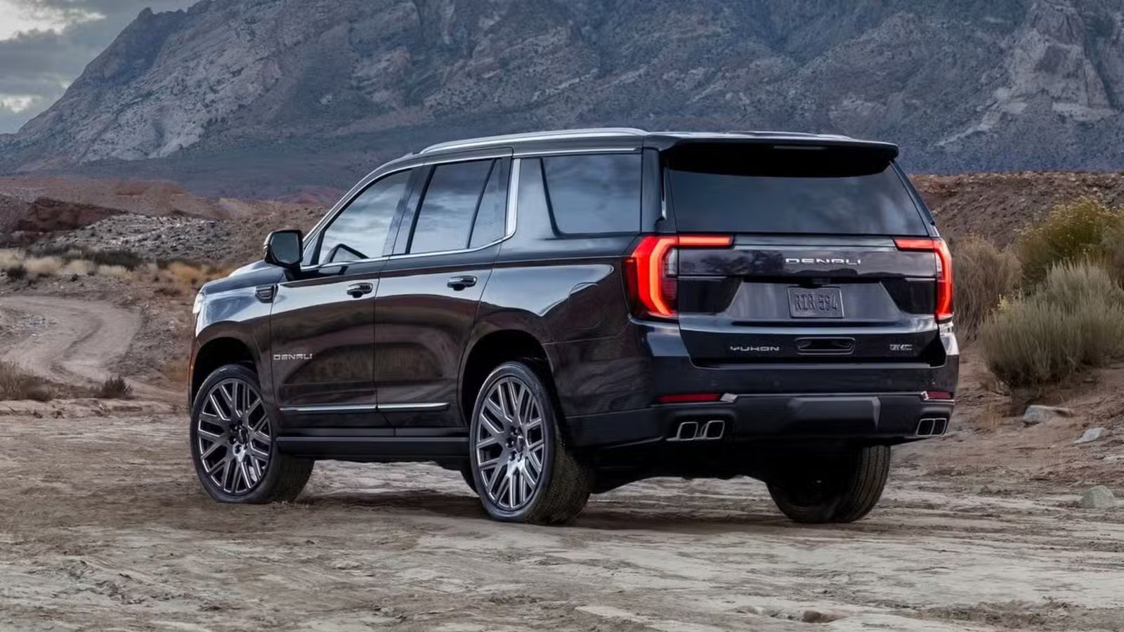 Plan 3/4 arrière statique d'un GMC Yukon Denali 2025 noir.