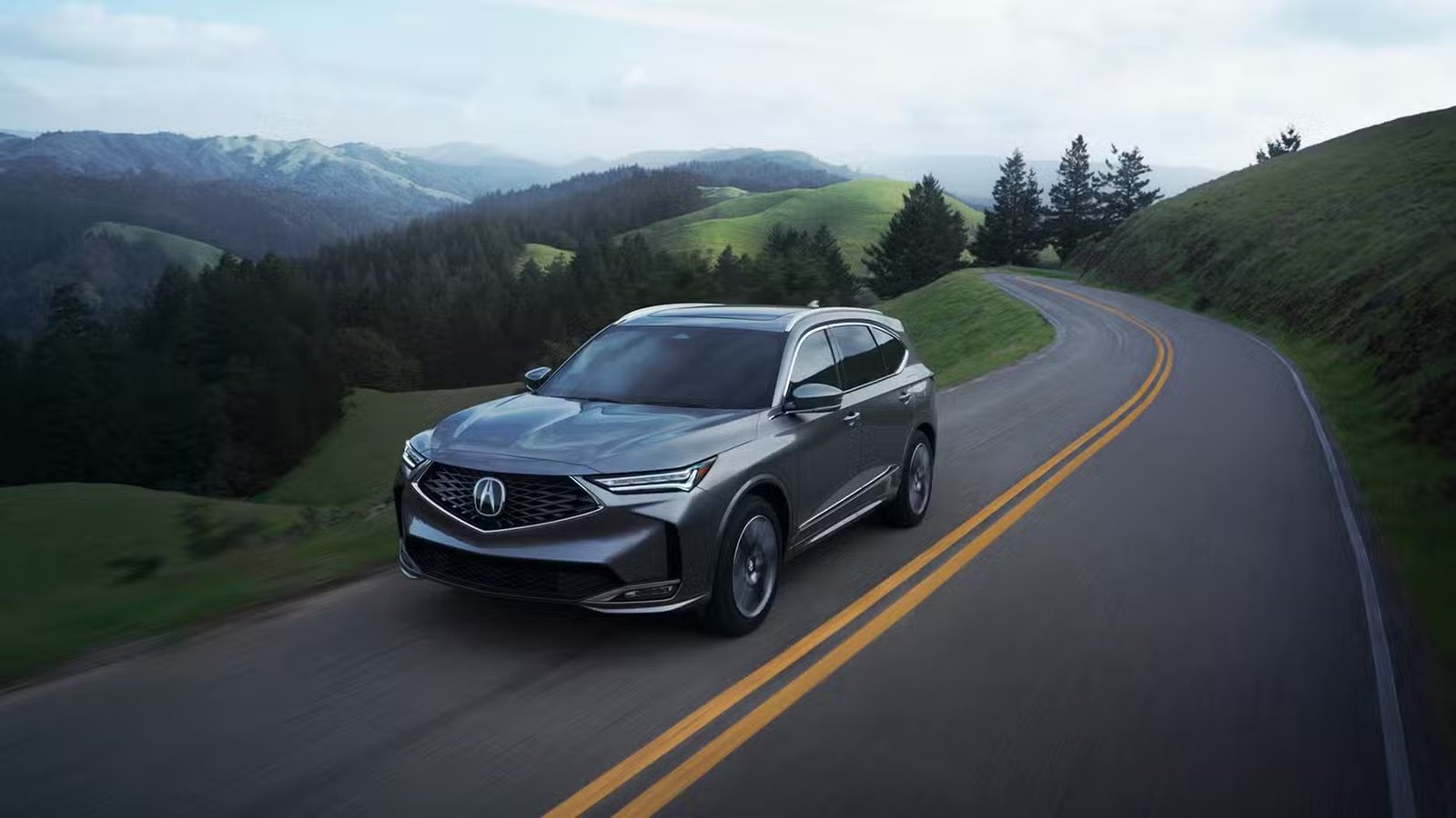 Plan dynamique 3/4 avant d'une Acura MDX 2025 grise avec ensemble Advance.