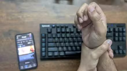 Se tenir la main à cause de la douleur des brefs sur un clavier.