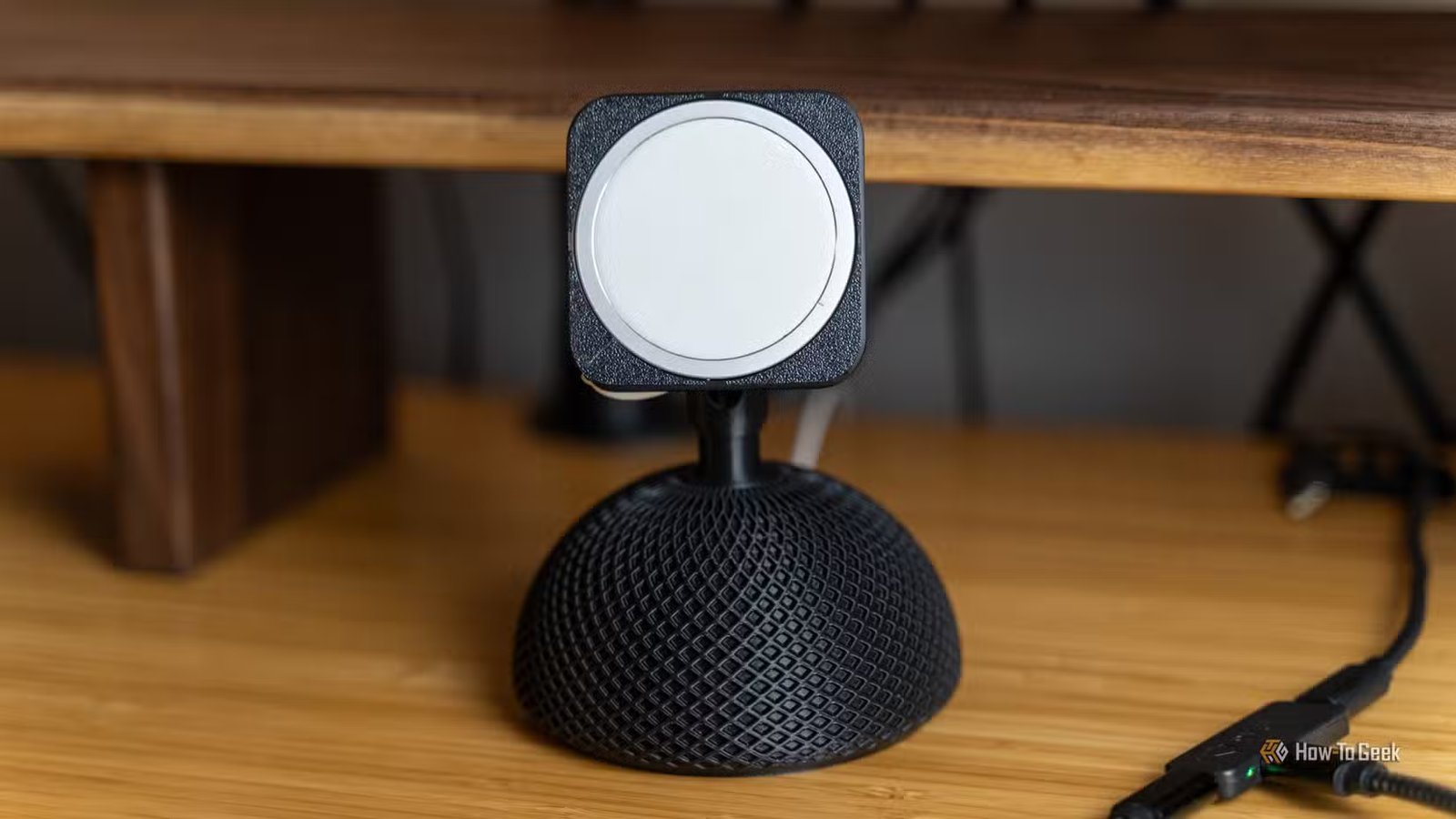Un support de téléphone MagSafe imprimé en 3D inspiré de l'iMac, posé sur un bureau en bambou.