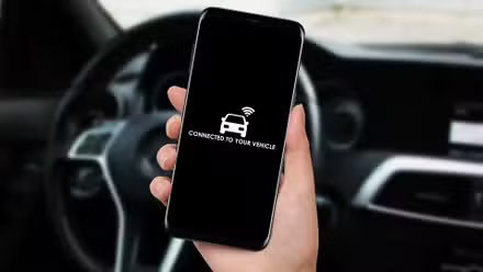 Femme connectant sa voiture avec son smartphone et son application via WiFi.